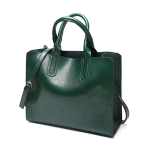 Detailed view of dark green PU leather tote bag with sturdy handles and adjustable strap