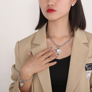 Detailed view of silver heart jewelry set with crystal pendants on a fashion model
