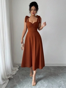 Elegante karamel midi-jurk met strikbandjes en hartvormige halslijn met taille