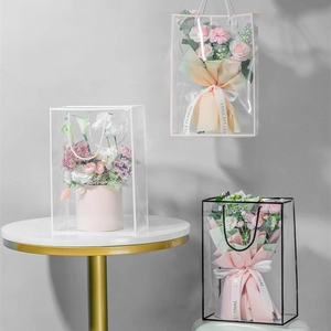 Close-up of clear PVC flower gift bags with elegant handles and decorative ribbons
