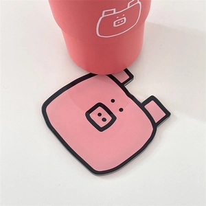 Close-up of a pink cartoon pig acrylic coaster with matching cup on white background
