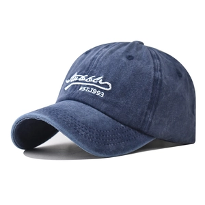 Vista macro del ricamo bianco 3D EST.1993 sul cappellino in cotone blu effetto lavato