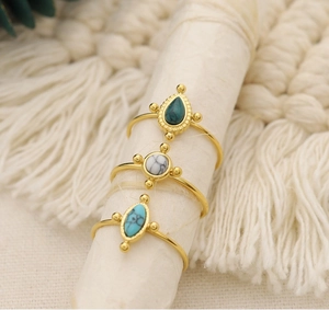 Detailed view of three vintage gold rings with green turquoise and marble stones