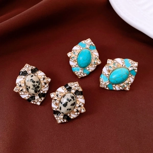 Détails de boucles d'oreilles vintage en émail avec pierres turquoises sur soie