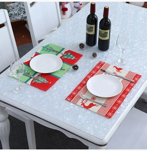 Detailed view of Christmas placemats with reindeer and tree patterns on a festive table