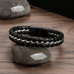 Handmade woven leather bracelet with stainless steel chain on natural pebbles