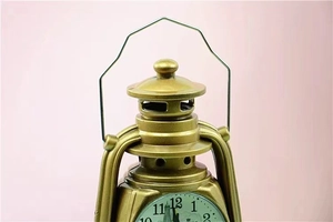 Close-up of the vintage gold lantern alarm clock with a metal handle on pink background