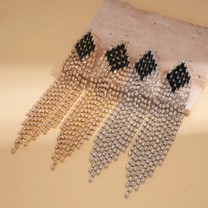 Macro detail of rhinestone tassels and black geometric gems on long drop earrings