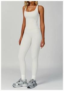 Detail of ribbed knit yoga set showing texture on cream sleeveless top and high waist leggings