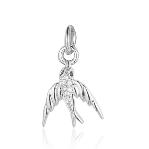 Macro detail of a silver swallow bird charm inlaid with sparkling zircon diamonds