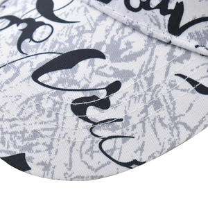 Close-up of baseball cap featuring graffiti script letters and detailed brim stitching