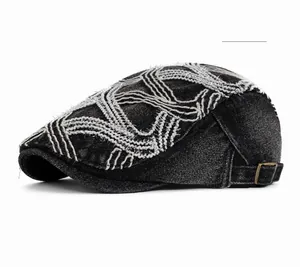 Detail of black denim beret featuring white contrast stitching and copper metal buckle