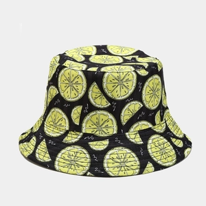 Detailed pattern of black bucket hat with yellow lemon print and white wavy lines