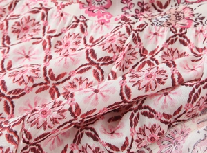 Close-up of lightweight floral print fabric in pink and cream for summer skirts