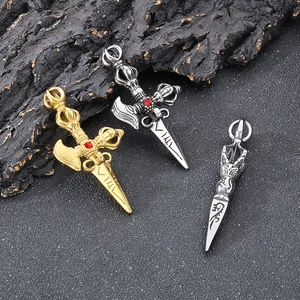 Vintage titanium steel cross vajra pendants with red ruby inlay on dark wood background