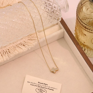 Nahaufnahme einer goldfarbenen Titanhalskette mit einem mit Kristallen besetzten Kreuz