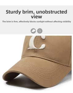 Close-up of khaki baseball cap featuring white embroidered C letter and durable stitched brim