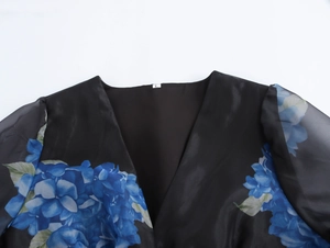 Dettaglio dell'abito in organza floreale con scollo a V, etichetta taglia e maniche