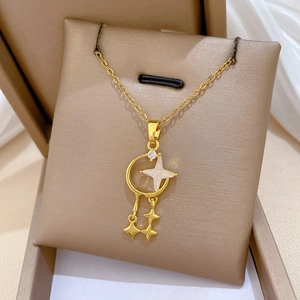 Macro detail of gold star and crescent moon pendant necklace with tassel charms