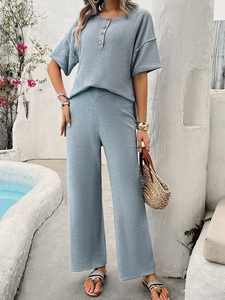 Detail of grey-blue waffle knit fabric texture on V-neck short sleeve top and pants set