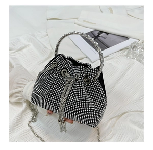 Detailed view of black rhinestone bucket bag with metal ring handle and chain strap