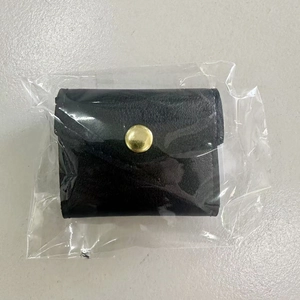 Detailed view of a soft black leather jewelry pouch featuring a stylish golden metal snap