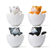 Detailed view of four cute kittens popping out of white eggshells for fairy garden decor