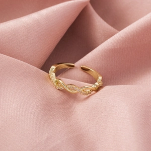 Close-up of golden hollow heart ring with pink zircon pavé on a pink silk background