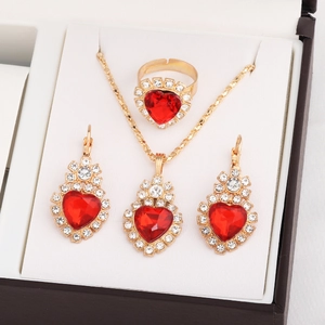 Elegant bridal jewelry set with red heart gems and sparkling diamonds in a gold-toned gift box