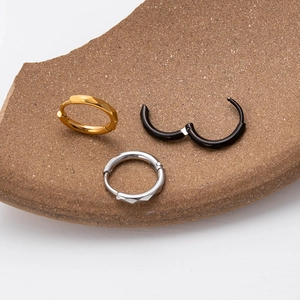 Polished stainless steel hoop earrings in gold silver and black with faceted patterns