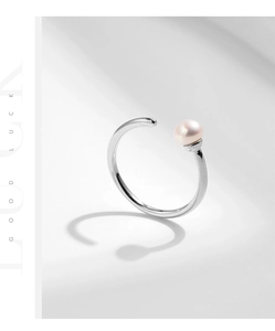 Detail of minimalist 925 silver ring with a pink natural pearl and Good Luck engraving
