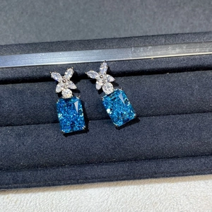 S925 Sterling Silver Flower Stud Earrings with Radiant Cut Blue Gemstone on Velvet Stand