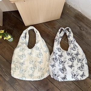 Detail of vintage canvas tote bags with butterfly prints and frayed tassel edges