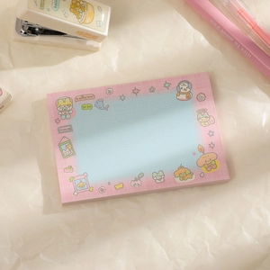 Close-up of pink checkered cartoon sticky notes with light blue writing area on desk