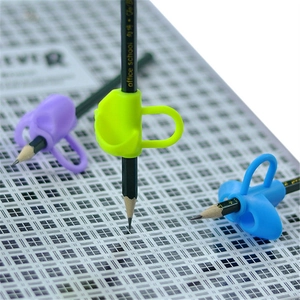 Detailed close-up of soft silicone dolphin-shaped pencil grips for writing posture correction