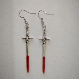 Detail of gothic silver sword earrings with red blood drop tip on grey background