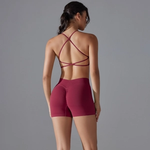 Detail showing cross-back design of the deep red sports bra and scrunch butt yoga shorts