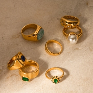 Detailansicht vintage 18K vergoldeter Zirkonia-Ringe mit Perlen auf Stein-Hintergrund