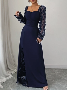 Détail de robe longue bleu marine avec broderie en maille et motifs floraux