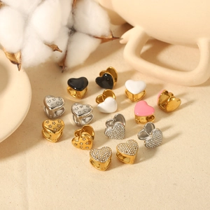 Macro view of 18K gold heart earrings with enamel finish and shimmering crystals