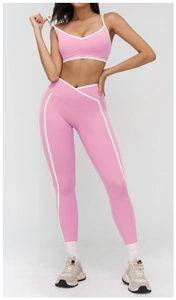 Detail of pink yoga set showing V-neck sports bra with white trim and high-waist leggings