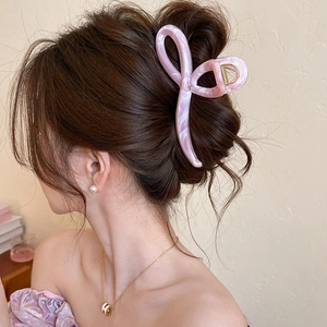 Detail of pink marble acrylic hair claw clip showing elegant cross-line design on hair