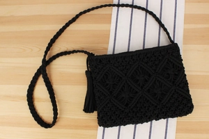 Close-up of black cotton rope woven bag showing diamond hollow pattern and tassel detail