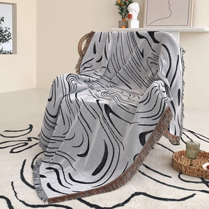 Detailed texture of bohemian knit blanket with abstract lines and colorful tassel fringe