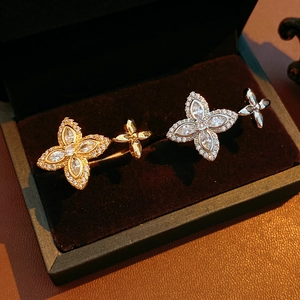 Vue rapprochée de bagues trèfle à quatre feuilles en or et argent avec zircons brillants