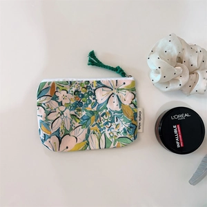 Detail of floral cotton coin purse with watercolor prints and dark green tassel zipper