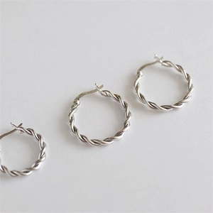 Macro shot of 925 sterling silver twisted hoop earrings with elegant texture design