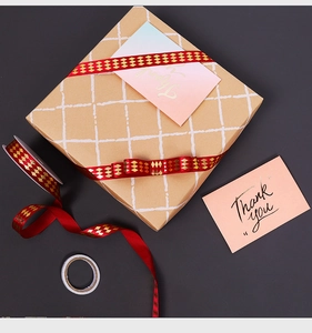 Detail of red bronzing diamond ribbon on kraft gift box with Thank You card