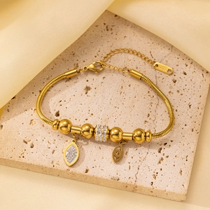 Detalle de pulsera de cadena de serpiente en acero inoxidable dorado con colgantes