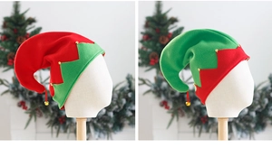 Detail of red and green velvet Christmas elf hats with golden bells for festive party
